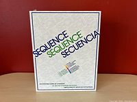 Front view of the Sequence board game box with branding and multilingual text.