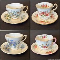 Four vintage floral teacups and saucers with various flower designs and gold trim, displayed individually in close-up to show pattern details.