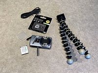 Kodak camera, tripod, charger cable, battery, memory card, and case on countertop