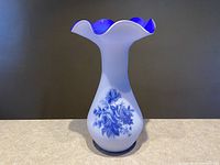 Front view of Norleans tall glass vase with blue overlay floral design and ruffled rim.