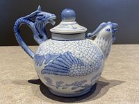 Photo of the full blue and white porcelain teapot showing dragon handle and chicken spout details.
