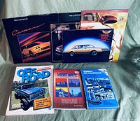 Photo showing eight automotive and related books arranged on a surface.
