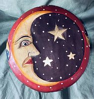 Top view showing detailed hand-painted crescent moon face and stars on stool seat.