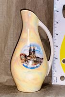 Front view of small ceramic vase showing Praha cityscape design and size relative to ruler.