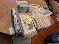 Box containing a variety of unused greeting cards and postcards, some in protective sleeves and bags.