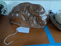 Front-side view of the carved wood water buffalo sculpture showing the detailed carving of the head and horns.