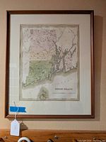 Full view of framed Rhode Island vintage map showing entire state with color divisions and wooden frame.