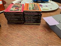 Stack of 26 Thomas the Tank Engine books showing the spines with titles and colors