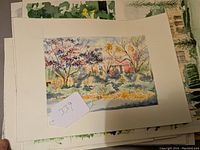 Watercolor painting depicting a garden scene with trees and a red building or shed in the background, framed by autumn or early winter foliage.