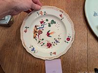 Front view of the Meissen dinner plate showing handpainted birds and floral designs with scalloped and decorated edge.