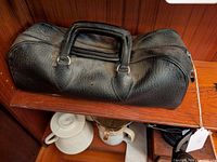 Full external view of the black textured leather physician's bag showing handles and zipper.