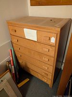 Full view of the oak dresser showing six drawers and protective covering on top.