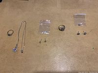Overview of all jewelry items including earrings, rings, and necklaces laid out on a surface.