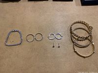 Photo showing the full lot including bracelets and earrings arranged on a flat surface.
