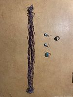 Full lot overview showing all jewelry pieces on beige surface: multi-strand purple beaded necklace, earrings, and ring.