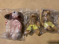 Three stuffed animals brand new in packaging, viewed from front