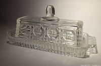 Butter dish with lid on, showcasing textured glass sides and knob handle on lid