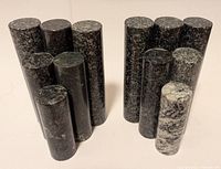 Pair of gray marble stylized bookends, seen from the side showing vertical cylinder stacks and texture variations.