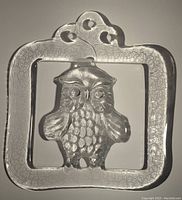 Front view of clear glass owl suncatcher with square frame and decorative top edge.