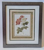 Photo of a framed botanical floral print showing two roses with green leaves, multiple mats, and a gray wooden frame.