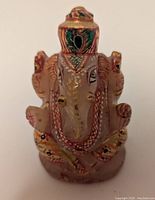 Front view of the handpainted Ganesh rose quartz statue showing detailed facial features and painted accents.