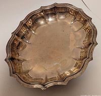 Top view of vintage WM Rogers silver plate serving dish showing scalloped edges and overall patina.