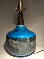 Full view of mid-century modern clay lamp base with blue glazed upper half, textured black/gray base, and teak wood neck with bulb socket.