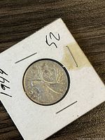 Reverse side of 1949 Canadian silver quarter depicting caribou and date 1949.