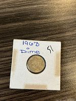 Obverse side of 1963 Canadian silver dime in cardboard holder showing Queen Elizabeth II profile