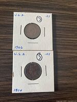 Front view of two Indian Head pennies in cardboard holders, showing dates 1906 and 1904.