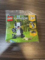 Front view of sealed Lego Creator 3-in-1 Panda Bear set in green plastic packaging showing the panda figure holding bamboo and nature elements.