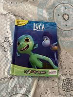 Front cover of Luca My Busy Book showing animated characters on a bedspread.