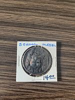 Front side of the Toronto Schoolboard Teachers Medal showing the embossed crest and design.