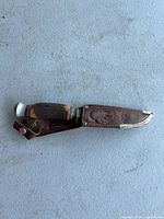 Knife in sheath showing the buffalo brand embossing on the leather.