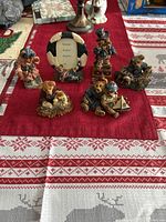 Six Boyds Bear collectible figurines arranged on a red and white patterned tablecloth, showcasing the variety of themes and designs in the set.