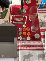 Photo showing the license plate bracket, beer glasses, poker chips, and a shot glass on a red patterned tablecloth.