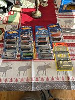 Full lot showing 14 unopened Hot Wheels cars in blister packs, including first editions and special models.