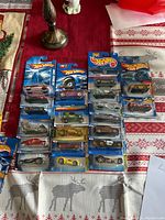 Overview photo showing 20 unopened Hot Wheels cars arranged on a table in original blue blister packs from the 2000s era.