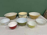 Three large ceramic mixing bowls at back and five smaller ceramic bowls front