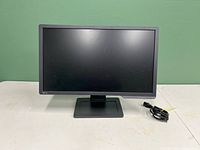 Front view of the BenQ 24-inch monitor powered off with included power cable next to it.