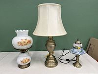 Photo of all three electric lamps arranged side by side showing size differences and design details.