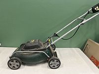 Side view of the Yardworks electric lawn mower showing aluminum handle and black and green body.