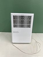 Front view of white NOMA dehumidifier with vent grille and power cord.