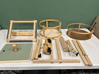 Overall lot: rectangular frame, two round frames, wooden rail attachments on white table against green background