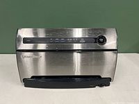 Front view of Foodsaver V3840 vacuum sealer unit with stainless steel front and black plastic handle.