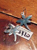 Photo showing the back side of two sterling silver dragonfly earrings with a tag showing the lot number and condition note.