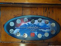 Front view of the coin collection case containing 14 uncirculated Canadian coins themed for Millennium Canada 2000 with Earth image background.