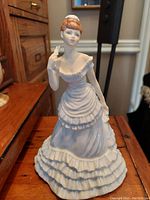 Front view of Coalport porcelain figurine "Donna" showing detailed facial painting and ruffled dress.