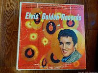 Front cover of 'Elvis Golden Records' vinyl LP album with colorful psychedelic background and Elvis portrait.