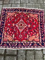 Top-down view of the entire rectangular carpet laid on pavement showing full design and colors.